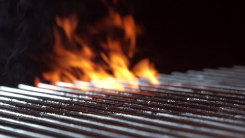 Empty hot barbecue grill with a flame of fire and smoke is burning, slow motion.