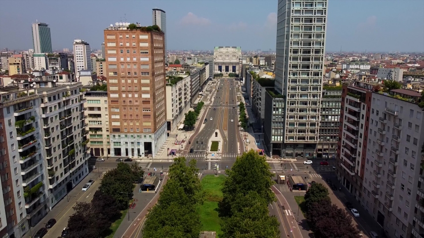 Milan, Italy, 08/28/2020: Aerial view of the central station and the long boulevard Via Vittor Pisani. Roofs of houses. Railroad station. Piazza Duca d'Aosta. Empty street. Pov.  | Shutterstock HD Video #1058189962