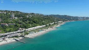 Traffic on the road leading to the city. Drone flying along big urban area over endless lines of small houses. Road to the seashore. buildings and people at the beach. Sochi, Russia, Black sea. 