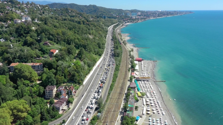 Highway traffic jam leaving big city. Aerial drone panorama view. from above at sunny day. Sea. Sochi. Russia 