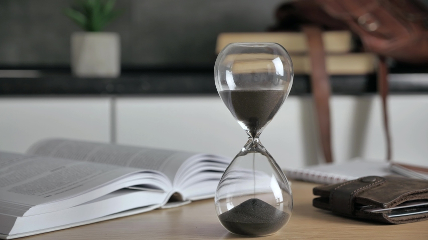 Sand clock time lapse. Hourglass on wood desk Sands move through hour glass. 4k Royalty-Free Stock Footage #1058193577