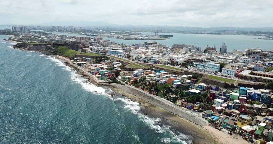 Cinematic Aerial of San Juan, Puerto Rico. Colorful La Perla Neighborhood, Castillo San Cristobal and Atlantic Ocean Coast