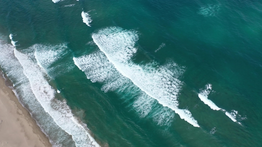 Beautiful drone footage of waves at the shore of Tottori desert in Japan, white waves and lazure blue sea, drone view of ocean waves | Shutterstock HD Video #1058196964