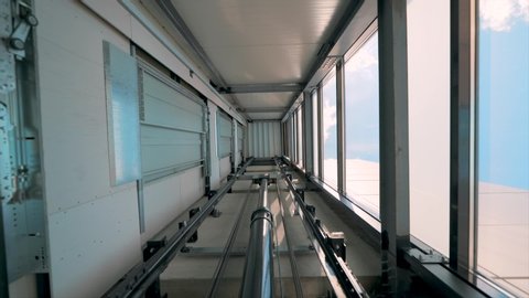 Elevator lift cabines up inside illuminated elevator shaft with hydraulics with many floors slow motion