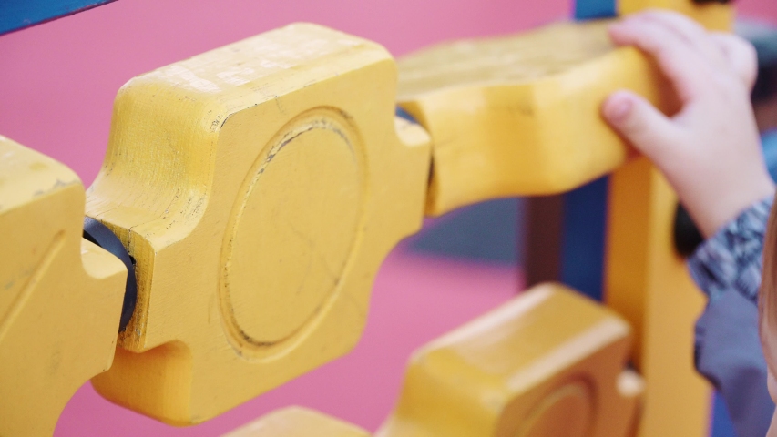 A boy plays a puzzle in a jumpsuit on the playground