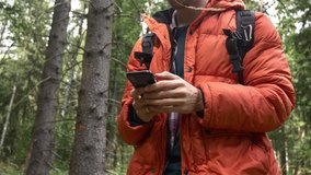 Young guy using a mobile phone in the woods