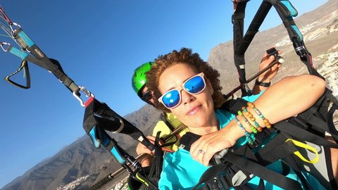 Paragliding in the sky. Paraglider tandem couple fly happy enjoying adrenaline experience together. Active adventure people outdoor. Summer experience on vacation