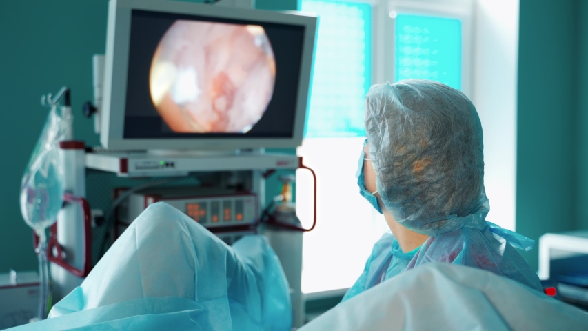 Doctor looks on medical monitor. Female specialist in medical uniform making operation to a patient and observes detail organs of a patient on the screen. Modern medicine. | Shutterstock HD Video #1058218666
