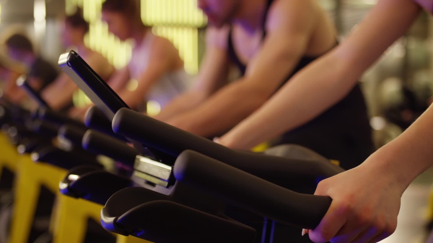 Group of athletic young people stationary bicycle doing spinning at gym . A group of young women and men train on sports training equipment in a fitness gym . Healthy Lifestyle and Sport Concepts Royalty-Free Stock Footage #1058222182