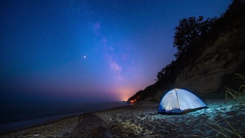 Amazing time lapse with Milky Way galaxy,  plane trails and a tent at a sandy beach,  Black sea coast, Bulgaria