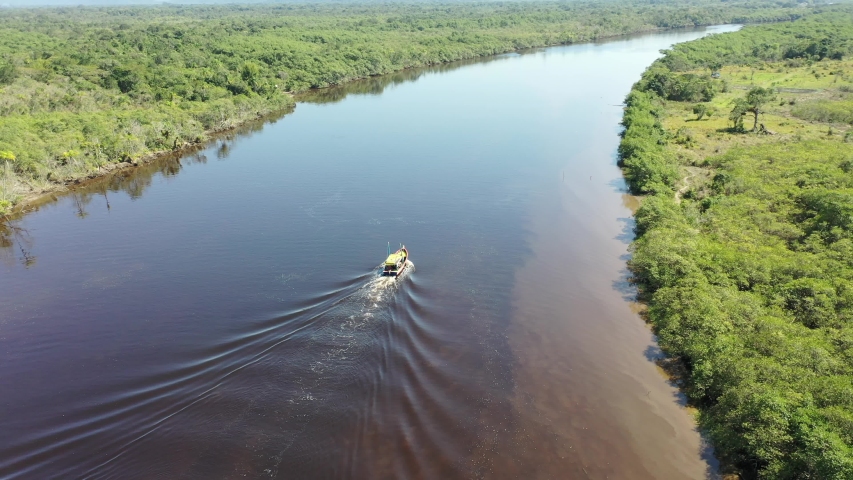 Aerial Landscape of Boat Sailing in the Dark River, Itanhaem, Sao Paulo, Brazil. Pantanal of Itanhaém. 
Conservation area. Boat in River, Itanhaem, Brazil. Scenic Pantanal, Brazil. Beauty in Nature Royalty-Free Stock Footage #1058227558