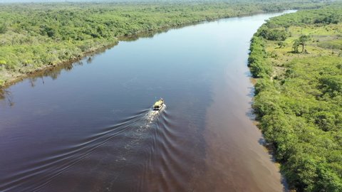 Aerial Landscape of Boat Sailing in the Dark River, Itanhaem, Sao Paulo, Brazil. Pantanal of Itanhaém. 
Conservation area. Boat in River, Itanhaem, Brazil. Scenic Pantanal, Brazil. Beauty in Nature