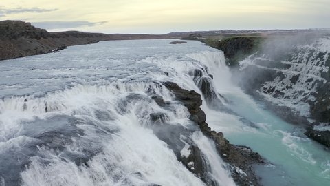 Aerial drone flight over fantastic gorgeouse big great waterfall at Iceland, 4k. Beautiful view at strong streams of crystal blue water at winter.