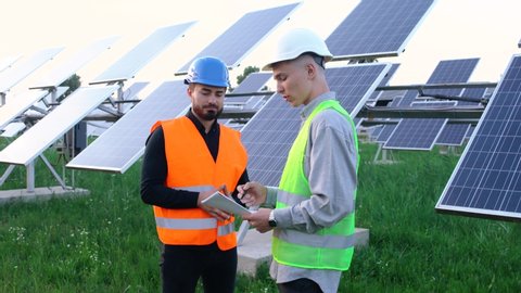 A team of professional engineers learning the design of the solar plant paper plan. Construction of photovoltaic solar panels.  