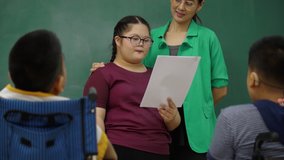 Asian girl with autism doing activities in classroom Practice your speaking skill with your school friends. Teacher guide with autistic to develop the brain of expression. Concept Education - Powered by Shutterstock - Get 15% off with code: PIKWIZARD15