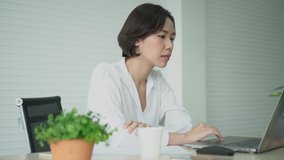 close up young asian woman sit in private room with serious moody and using laptop to checking email or proof work from colleagues for work from home business and technology lifestyle concept