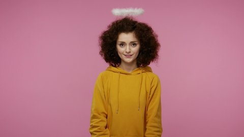Take this present! Charming angelic young woman afro hairstyle with saint halo giving wrapped gift box to camera and smiling, congratulating on holidays, donation charity concept. studio shot isolated