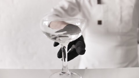 Bartender Mixologist Puts Empty Cocktail Glass on Bar Counter