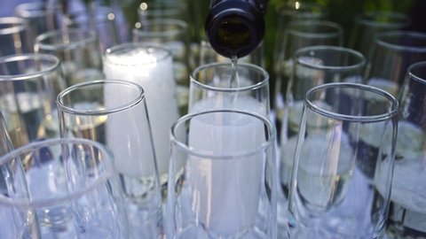 champagne is poured into glass glasses from a bottle. catering or buffet in the fresh air. alcoholic and non-alcoholic beverages