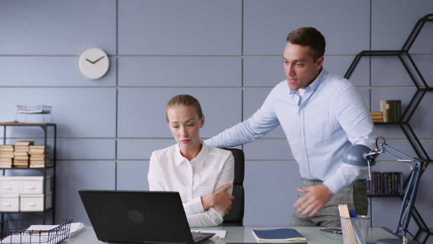 male chief stands and female subordinate sits at table with laptop in office. man yells and reprimands, looks aggressive and angry. woman is scared and feels panic, looks sad and worried. Royalty-Free Stock Footage #1058257651