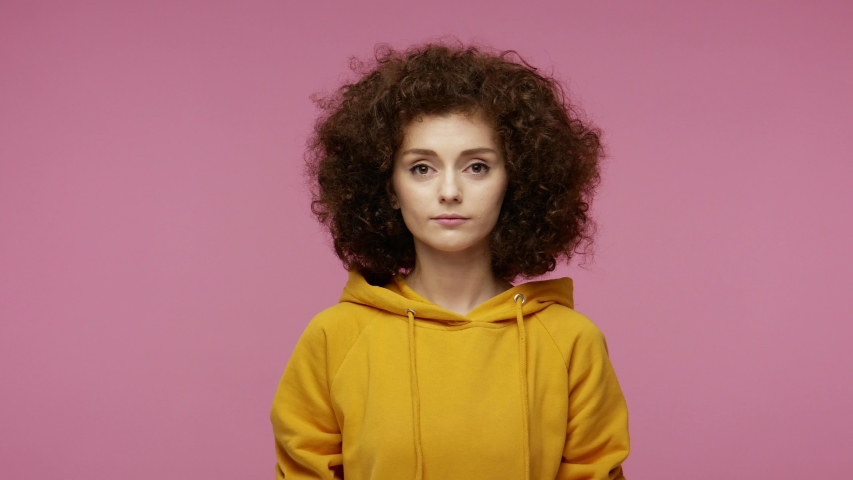 Cunning young woman afro hairstyle in hoodie thinking devious tricks cheats, twiddle fingers smirking and scheming evil plan, trying to plot something sly in mind.  isolated on pink background Royalty-Free Stock Footage #1058259337