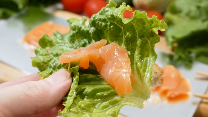 fresh salmon fish with green lettuce and vegetables, fresh salad with greens, salmon and croutons, raw food diet concept