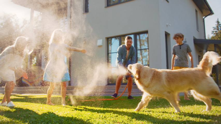 Smiling Father, Daughter, Son Play With Loyal Golden Retriever Dog, Spraying Each other with Garden Water Hose. On a Sunny Day Family Having Fun Time Together Outdoors in Backyard. Slow Motion Shot Royalty-Free Stock Footage #1058262007