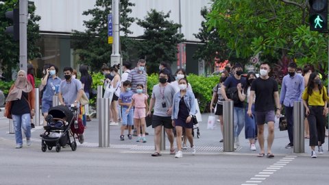Singapore / August 31, 2020: People wearing face masks at busy pedestrian crossing, Orchard Road.