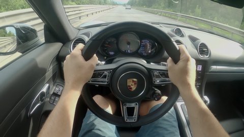 LJUBLJANA, SLOVENIA, MAY 2020, POV: Man is driving down the empty highway in a brand new black Porsche supercar. Awesome first person shot of a drive down an empty freeway in a luxury Porsche car.