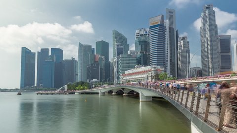 Esplanade bridge and downtown core skyscrapers in the background Singapore timelapse hyperlapse. Illuminated towers reflected in water