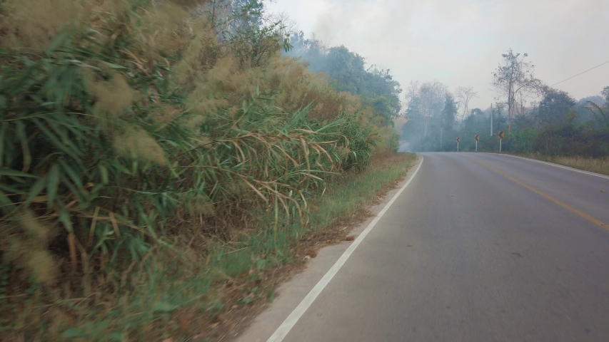 Driving along a mountine road while bushfire and smog season in Thailand. Point of view driving. POV driving footage 4K