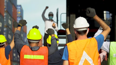 Workers protest in Cargo freight ship for import export logistic During corona virus or covid 19 outbreak . Group of protestors fists raised up in the air . Strike of labor in industry 
