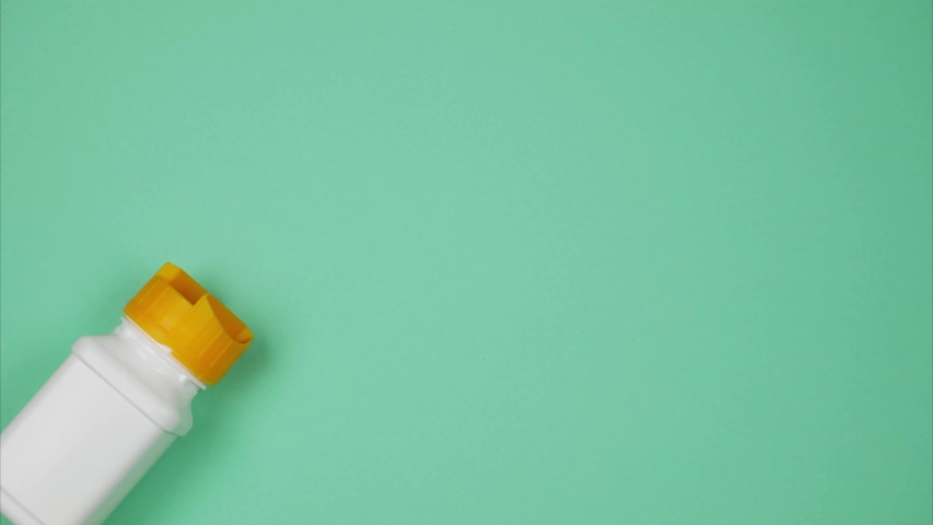 Orange pills explode out of a bottle.  Space for text. Stop motion animation