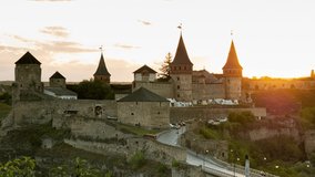 Day to Night Timelapse of Medieval Castle With Running Clouds And Cars Driving Next to the Landmark. Evening Video Shot of Kamyanets-Podilskyi Fortress in Sunset