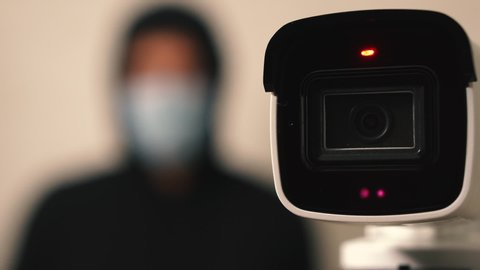 A camera with sensors measures a person's temperature during quarantine due to the covid-19 coronavirus pandemic. Close-up camera and a silhouette of a person out of focus
