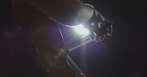 Footage of female hands playing cello violoncello . Musician Woman plays in beautiful contrabass on stage in concert . Close up . Shot on ARRI ALEXA movie camera in slow motion .