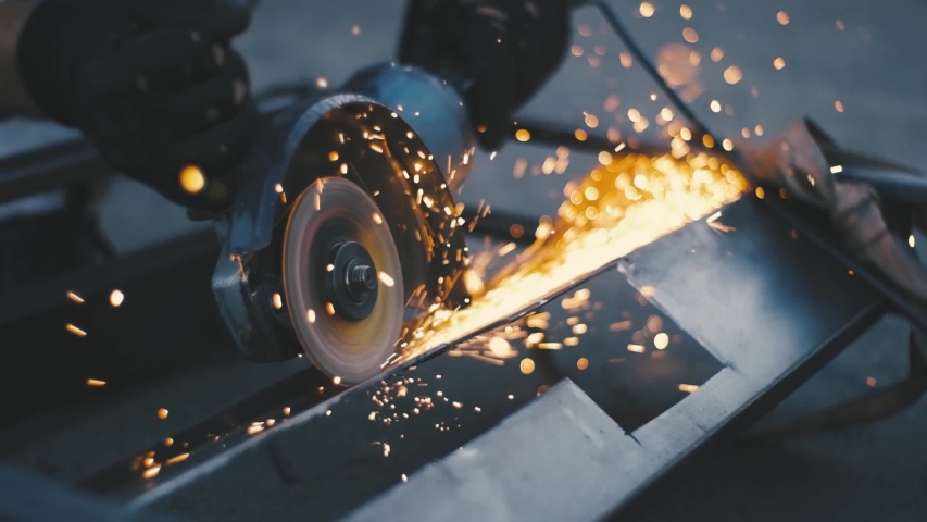 Man works circular saw. Sparks fly from hot metal. Man hard worked over the steel. Close-up slow motion shot in garage | Shutterstock HD Video #1058281453