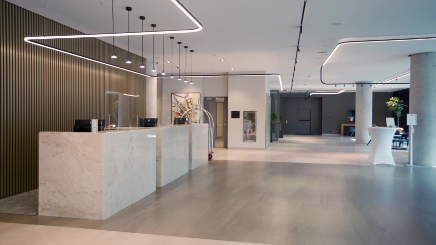 Interior of a hotel lobby with reception desks with transparent covid plexiglass lexan clear sneeze guards Royalty-Free Stock Footage #1058290309