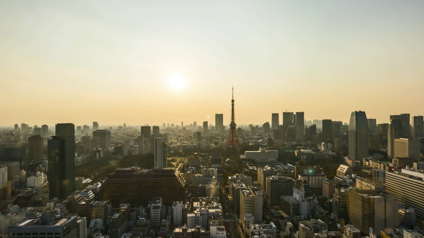 Sunrise scene at Tokyo city skyline. Cinematic look and flare effect. Tilt up. Clip may contain noise due to high ISO setting. 