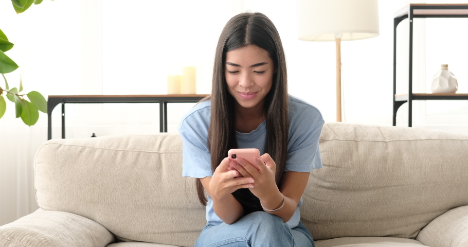 Woman displeased using mobile phone at home | Shutterstock HD Video #1058301271