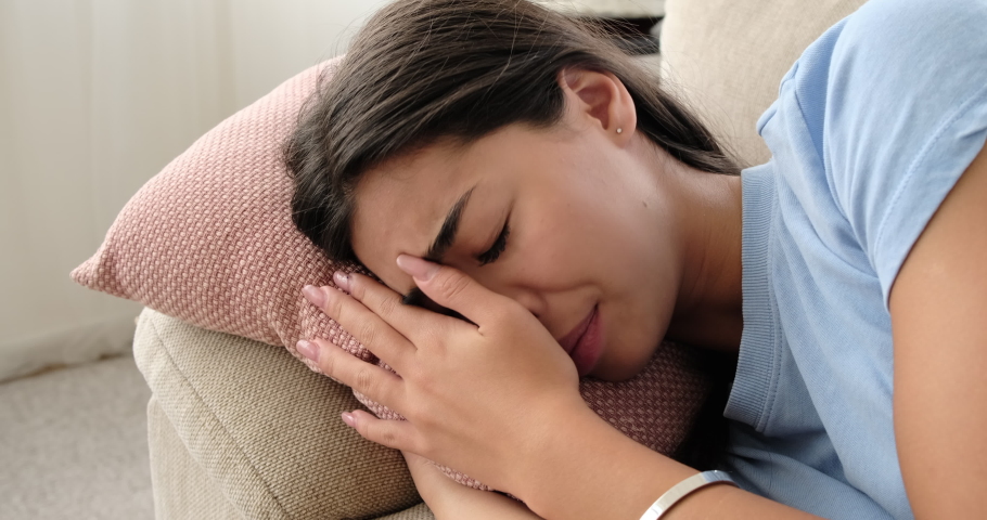 Sad woman crying on sofa at home | Shutterstock HD Video #1058301286