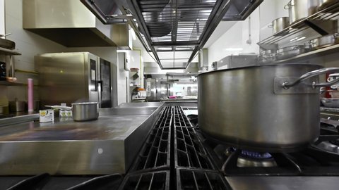 Preparing and cooking food in a commercial kitchen. Zoom out, Dolly shot camera movement. High quality 4k footage