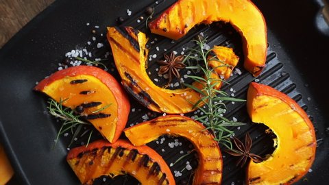 Fried and baked pumpkin with spices, herbs and grilled sea salt. Making homemade pumpkin dishes in the fall. Vegetable and vegetarian barbecue Stock-video