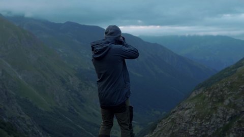 Traveler photographer takes photos on telephoto lens in mountains