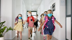 Group of cheerful children with face masks running on corridor, back to school concept. - Powered by Shutterstock - Get 15% off with code: PIKWIZARD15