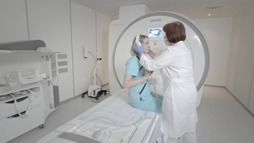 Doctor makes an MRI scan for a patient in a clinic. The girl lies in the MRI device. Magnetic resonance imaging in the study of the human body. Modern technologies in medicine. Examines lungs | Shutterstock HD Video #1058307277