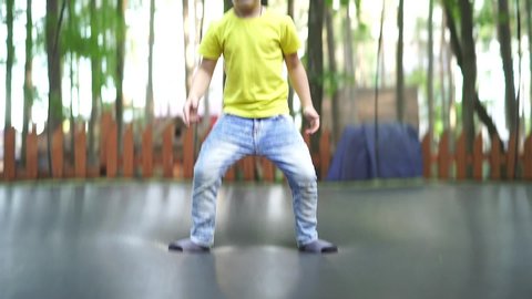 Happy boy jumps on a trampoline on a summer day in the open air. The child levitates. slow-motion video.