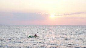 Excellent summer sunset on the sea and the silhouette of a man on a kayak. slow-Motion video.