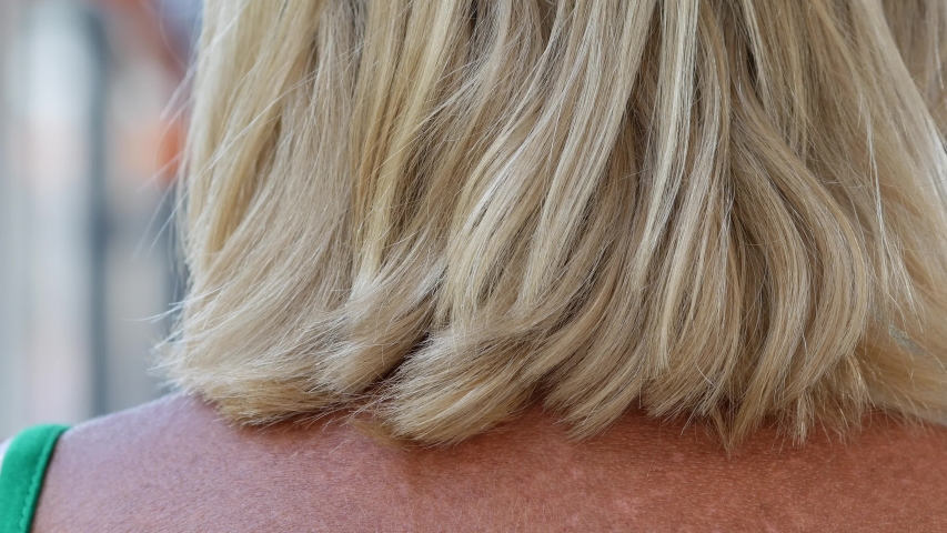 Women straight hair. Hairstyle on a woman head. Shoulder-length tinted hair. Stylish fashionable bob haircut. Elegant blond lady close up from the back