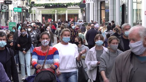 GHENT, BELGIUM – AUGUST 2020: Crowds of people wear compulsory face masks in downtown Ghent shopping street, Covid-19 coronavirus outbreak in Belgium